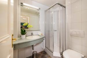 a bathroom with a shower and a toilet and a sink at Cresta Palace Celerina in Celerina