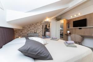 a bedroom with a large white bed with pillows at Pansion Tina in Šilo