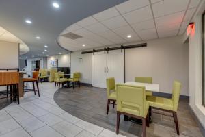 a waiting room with yellow chairs and tables in a building at Alexis Inn and Suites Hotel in Nashville