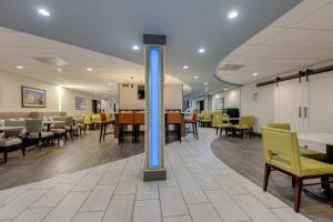 a dining room with tables and yellow chairs at Alexis Inn and Suites Hotel in Nashville