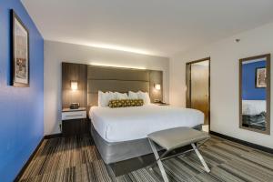 a hotel room with a large bed and a chair at Alexis Inn and Suites Hotel in Nashville