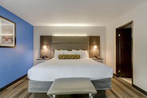 a large bed in a hotel room with blue walls at Alexis Inn and Suites Hotel in Nashville