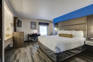a hotel room with a large bed and a desk at Alexis Inn and Suites Hotel in Nashville