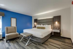 a hotel room with a large bed and a chair at Alexis Inn and Suites Hotel in Nashville