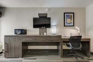 a desk with a television and a chair in a room at Alexis Inn and Suites Hotel in Nashville
