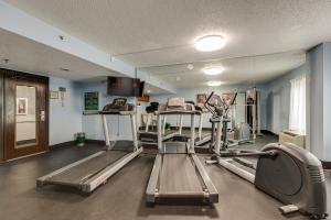 a gym with several tread machines in a room at Alexis Inn and Suites Hotel in Nashville
