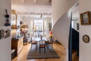 a staircase in a living room with a table and chairs at MaisondesChaumes-Paris in Paris