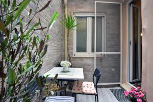 d'une terrasse avec une table, des chaises et une fenêtre. dans l'établissement Vergeta apartment, à Corfou