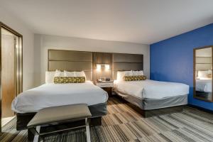 a hotel room with two beds and a chair at Alexis Inn and Suites Hotel in Nashville