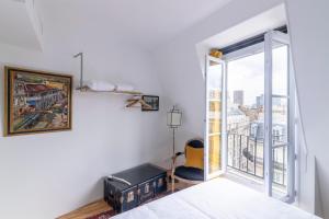 - une chambre avec un lit et une grande fenêtre dans l'établissement MaisondesChaumes-Paris, à Paris