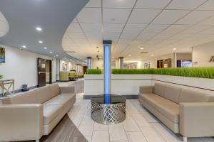 a lobby of a hospital with couches and plants at Alexis Inn and Suites Hotel in Nashville