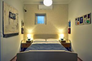 1 dormitorio con 1 cama y 2 mesitas de noche con lámparas en Vergeta apartment en Corfú