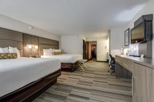 a hotel room with two beds and a flat screen tv at Alexis Inn and Suites Hotel in Nashville