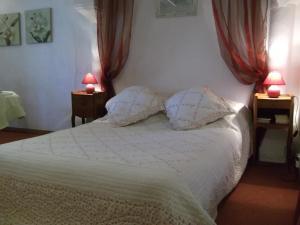 1 dormitorio con 1 cama blanca y 2 lámparas en La Closerie, en Saint-Philbert-du-Peuple