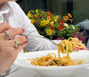 a person sitting at a table with a plate of food at SHG Hotel De La Ville in Vicenza