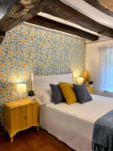 - une chambre avec un lit orné d'un mur fleuri dans l'établissement Apartamentos Río Cubo, à Cosgaya