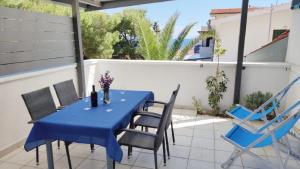 a blue table and chairs on a patio at Apartments Riba in Vis