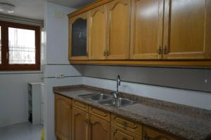 uma cozinha com um lavatório e armários de madeira em Apartament Duplex Camprodon em Camprodon