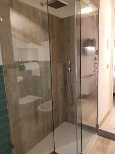 een douche met een glazen deur in de badkamer bij Santa Marta Rooms&Studios in Verona