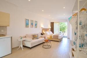 a white living room with a couch and a table at Meltemi Studios in Vasiliki