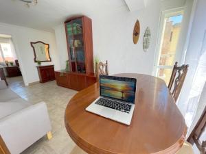 einen Laptop auf einem Holztisch im Wohnzimmer in der Unterkunft Casa Baelo, 3 bedroom apartment in Tarifa, Centric and close to Old Town and Beaches in Tarifa