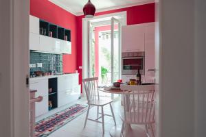 cocina con paredes rojas, mesa y sillas en Cà del Mago, en Lerici