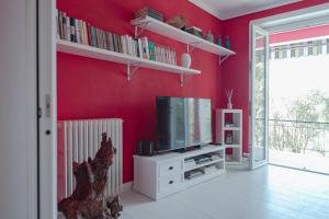 a living room with a tv and a red wall at Cà del Mago in Lerici