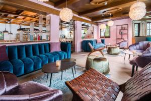 a lobby with blue couches and tables and chairs at Hotel Hörterer Der Hammerwirt in Siegsdorf