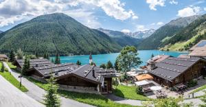 an aerial view of a village with a lake and mountains at Hotel & Chalets Edelweiss in Madonna