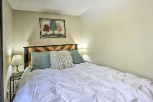 a bedroom with a large white bed with blue pillows at Cozy Cabin with Sunroom and Cacapon River Access! in Capon Bridge