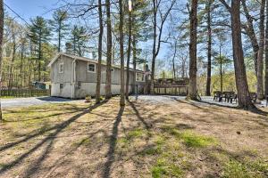 a house in the middle of a yard with trees at Cozy Cabin with Sunroom and Cacapon River Access! in Capon Bridge