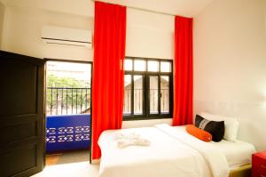 1 dormitorio con 2 camas y una ventana con cortinas rojas en Moonlight Champa en Vientián