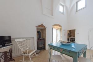 een woonkamer met een blauwe tafel en een tv bij La Casa e la Corte in Salve
