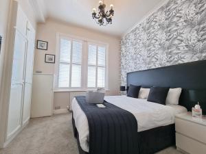 a bedroom with a large bed with a laptop on it at The Ashleigh - Dog Friendly in Bournemouth
