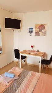 a room with a desk and a television on a wall at Apartman i sobe Martina in Senj
