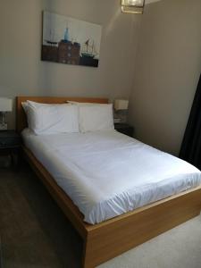 uma cama com lençóis brancos e almofadas num quarto em North Ings em Robin Hood's Bay