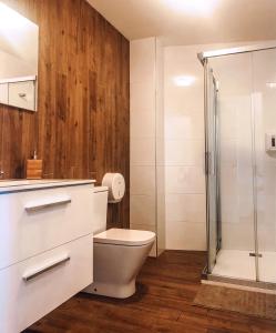 a white toilet sitting next to a shower in a bathroom at Villa Galicia in Caldas de Reis