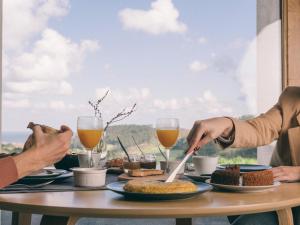 Hotel Boutique Nafarrola في بيرميو: يجلس شخصان على طاولة مع الطعام والمشروبات