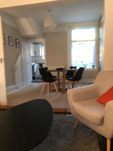 sala de estar con sofá, mesa y sillas en Radford Place - Central Exeter - Patio & Garden - Beach - Chiefs - Uni -WiFi en Exeter