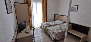 Kleines Zimmer mit 2 Betten und einem TV in der Unterkunft Hotel Rondine in Marinella di Sarzana