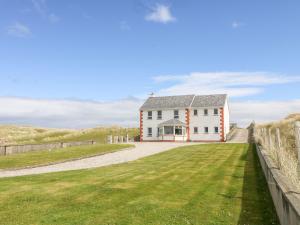 uma casa branca com uma cerca e um quintal em Realt na Farraige em Doirí Beaga