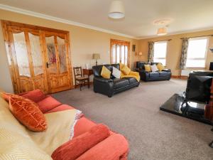 uma sala de estar com dois sofás e um sofá em Realt na Farraige em Doirí Beaga