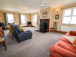 a living room with a couch and a fireplace at Realt na Farraige in Doirí Beaga