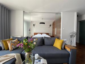 - un salon avec un canapé bleu et un lit dans l'établissement Aravel Old Town Apartments, à Wrocław
