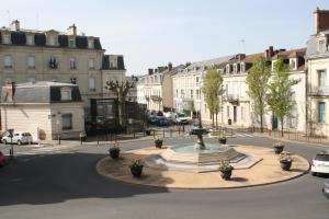 een fontein in het midden van een straat met gebouwen bij Péribleu in Périgueux