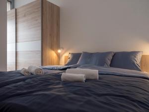 a large blue bed with two towels on it at Apartments Aura in Deskle