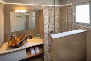 a bathroom with a tub and a sink and a shower at Kalya Suites in Kamari