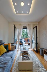 uma sala de estar com um sofá e uma mesa em Centar M LUX Zlatibor em Zlatibor