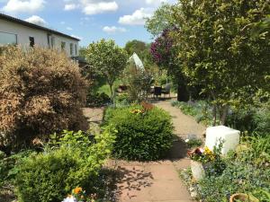 a garden with flowers and plants on a sidewalk at Bokelrehm 3 in Bokelrehm
