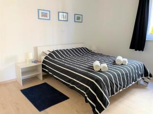 sypialnia z łóżkiem z czarno-białą kołdrą o paskach w obiekcie Apartment Punta Premantura E with garden w mieście Premantura